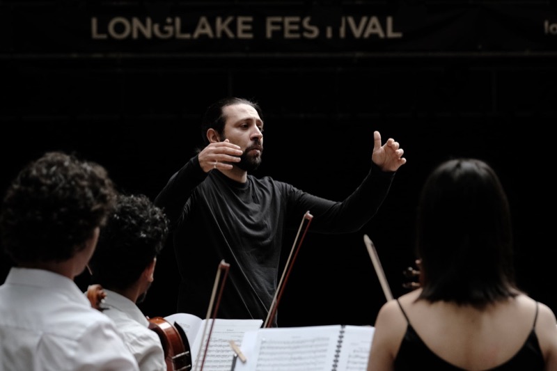 Francesco Bossaglia conducting on an outdoor festival stage at Longlake Festival, Lugano 2021.